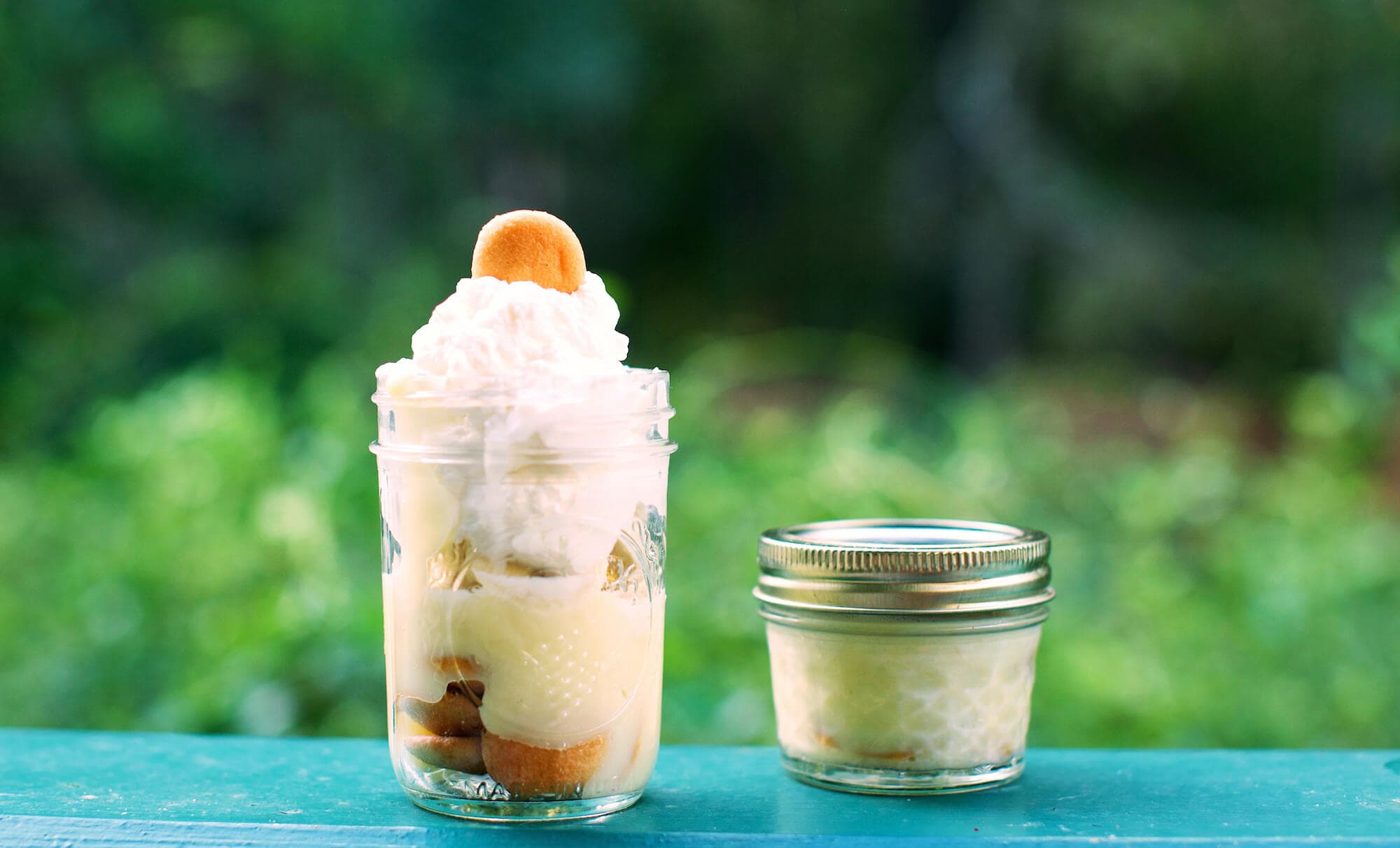 Banana pudding in mason jars, topped with vanilla wafers and whipped cream