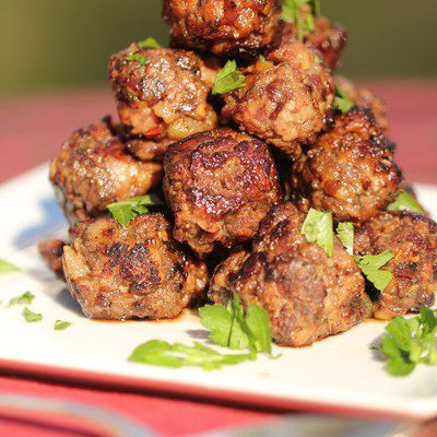 pyramid of duck meatballs on white platter