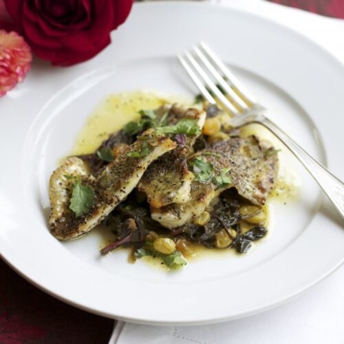 bream fillets with dandelion greens on white plate