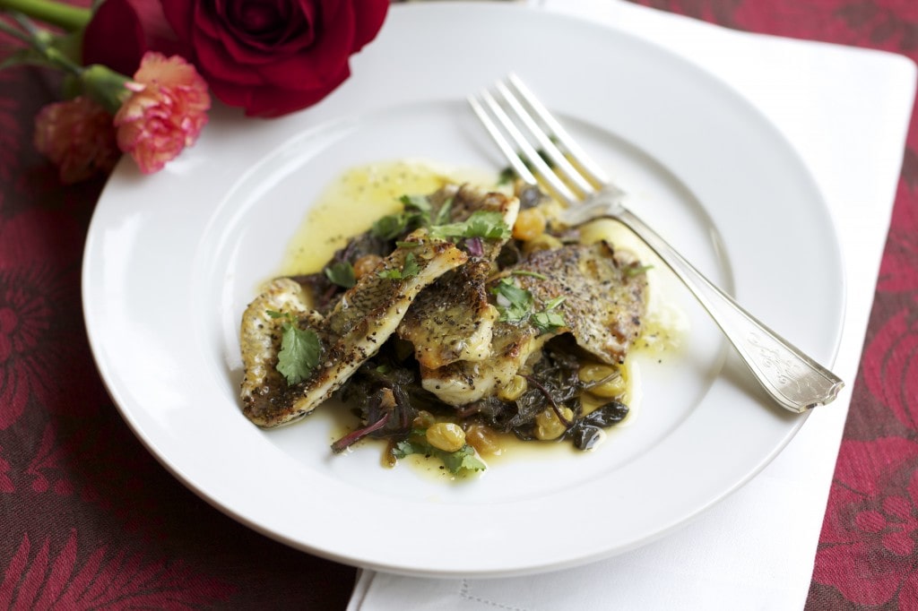 bream fillets with dandelion greens on white plate