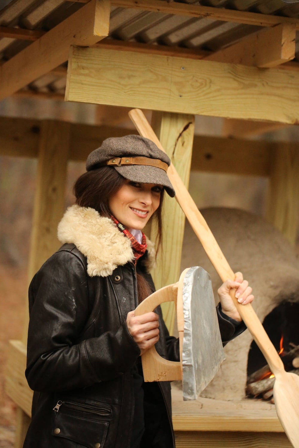 Stacy wearing a buff while cooking in the earthen oven