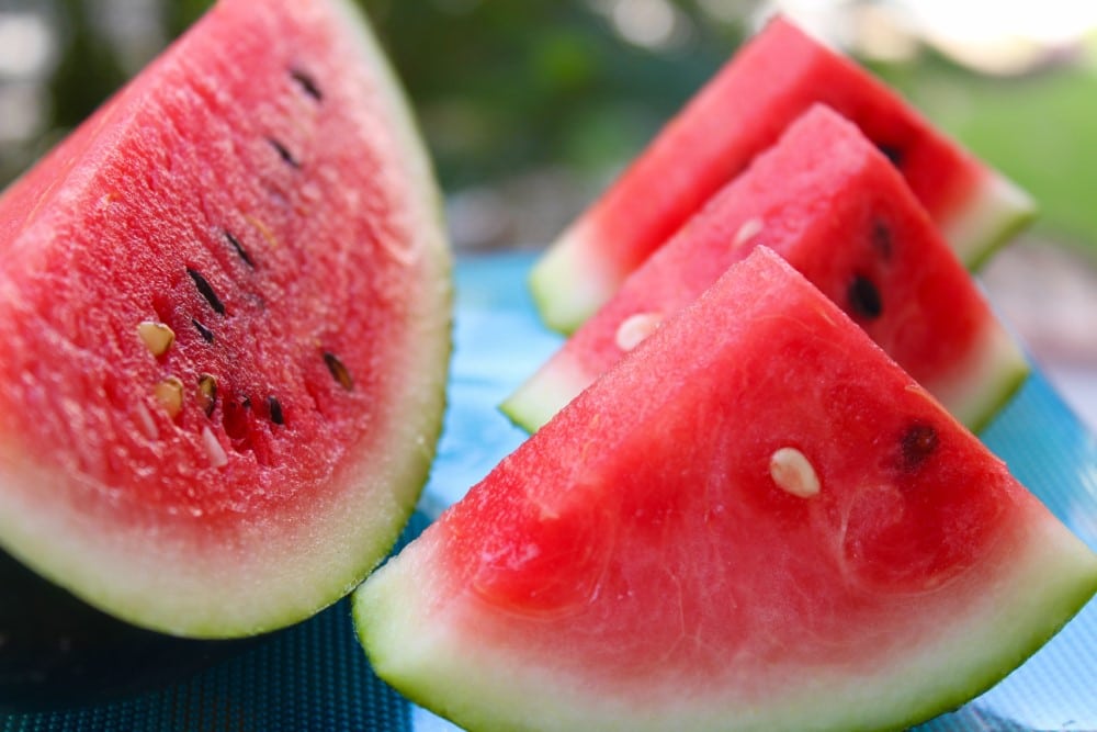closeup slices of ripe, juicy watermelon on blue cloth