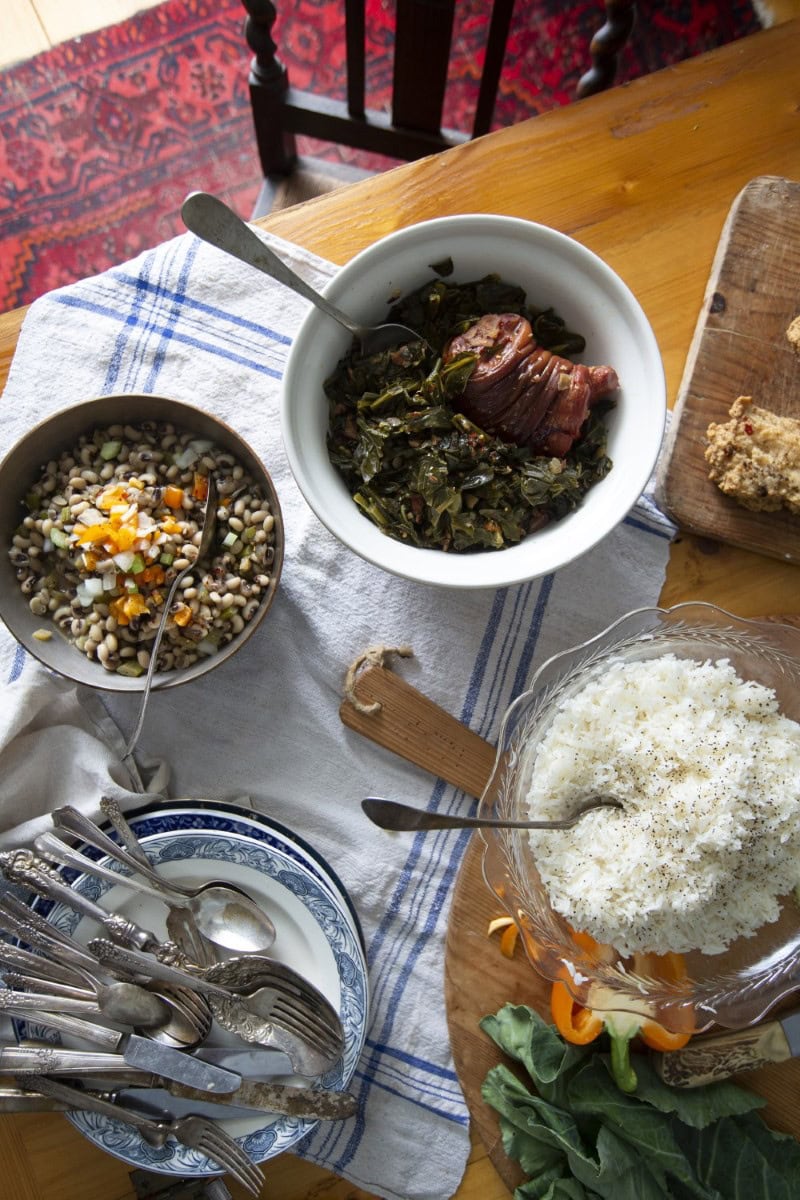 table loaded with southern classic dishes, featuring collard greens
