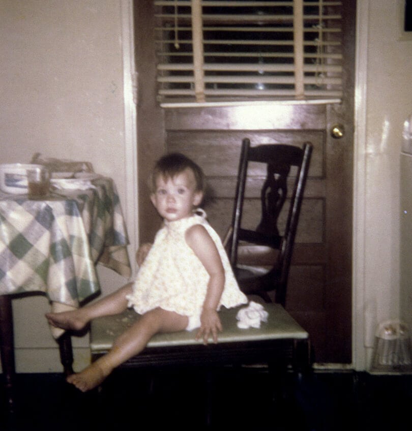 Stacy as a child sitting at her grandmother's table