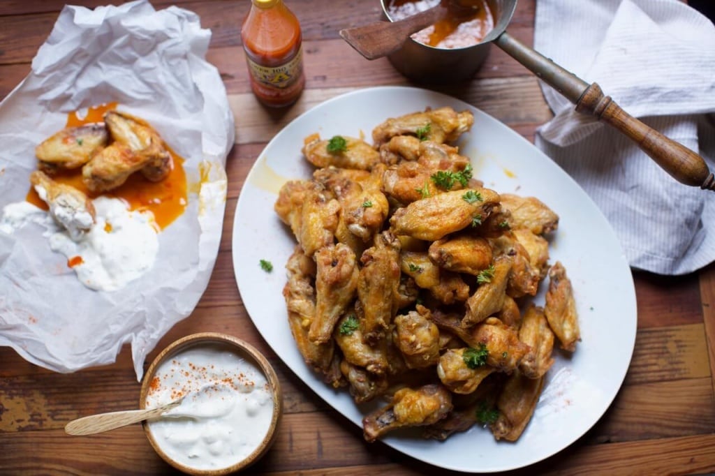 Full spread of spicy chicken wings and blue cheese dressing