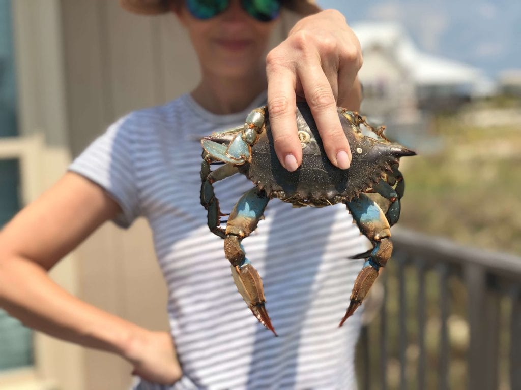 Stacy Lyn emphatically holding up a freshly caught crab