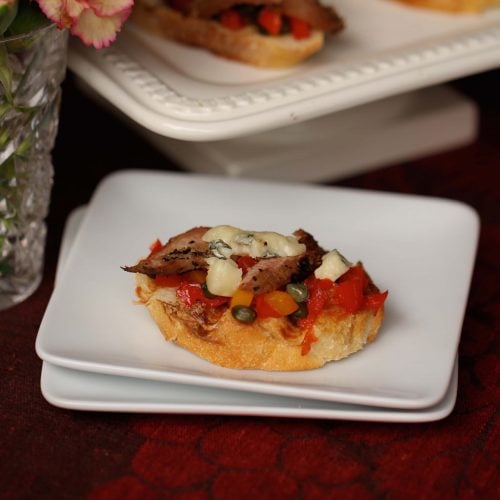 Bruschetta hors d'ouvres with venison, peppers, tomatoes, blue chees and olive oil