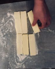 Sprinkle a little flour over the butter and parchment paper and roll the butter into a flat sheet with the rolling pin (recipe for how to make danish pastries by Stacy Lyn Harris)