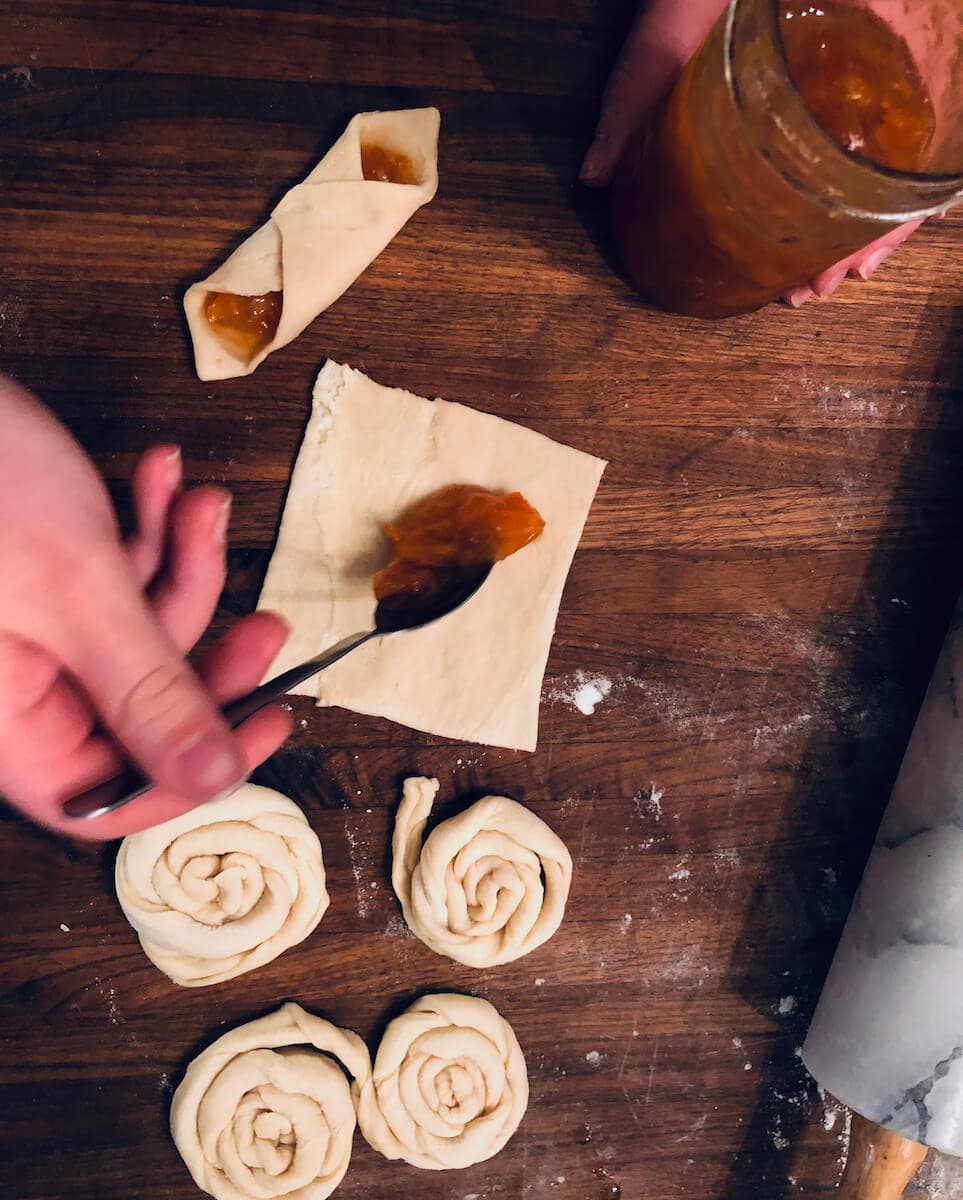 Place cream, pastry cream, or jelly diagonally into square pieces of dough. Fold the sides and seal the pastry together with an egg wash (recipe for how to make danish pastries by Stacy Lyn Harris)
