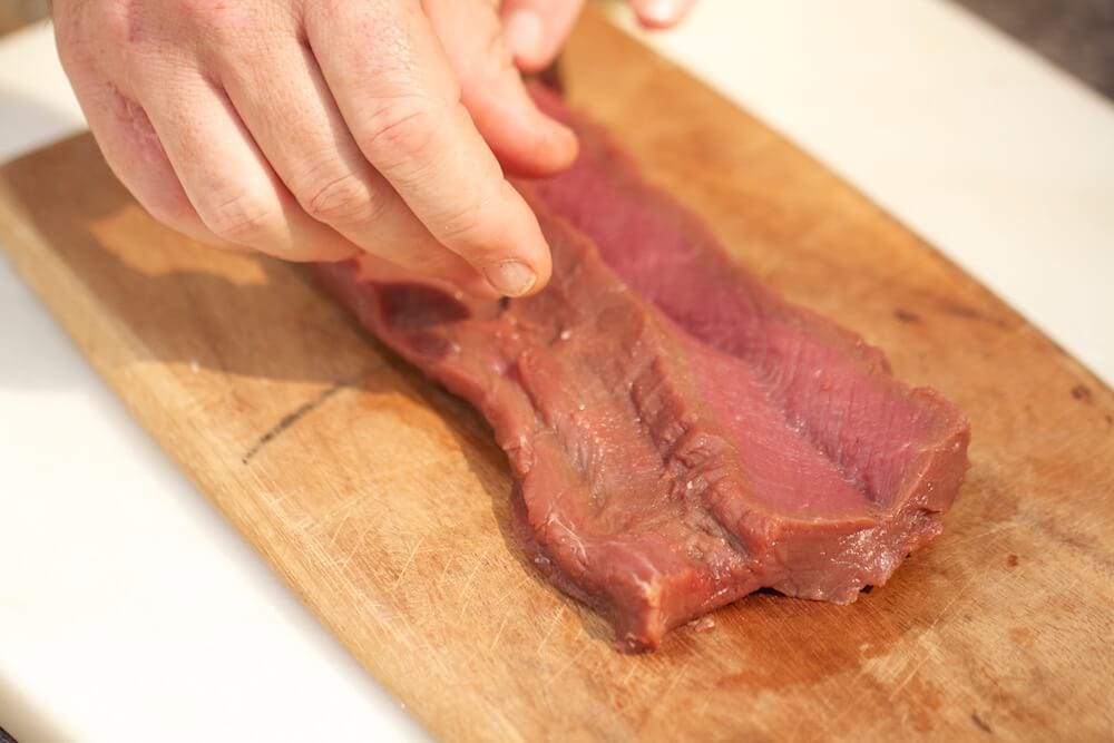 step 3 demonstrating how to butterfly venison loin, photo by Stacy Lyn Harris