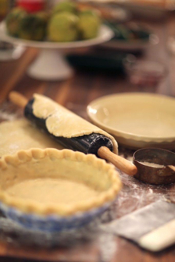 Homemade pie crust in pie shell and rolling pin with pie crust ready to go into pie shell