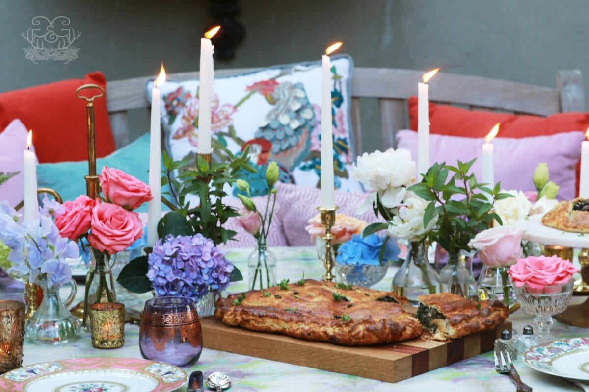 Kale Pastry Recipe surrounded by candles, flower arrangements, pillows in the seats and a table dressed in linen