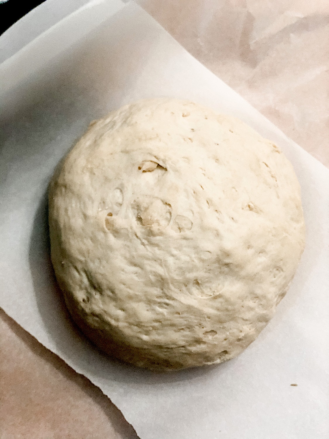 Dough that has risen a second time on a piece of parchment paper