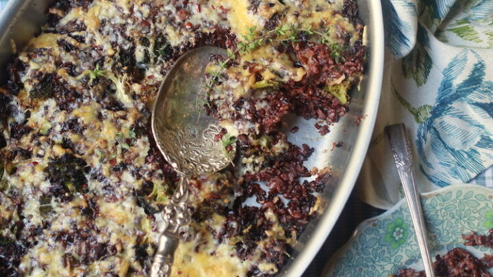overhead shot of wild rice with broccoli and cheese casserole with pretty blue floral plate and checked napkin