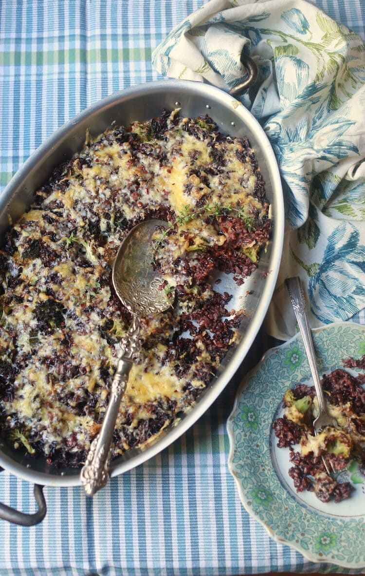 overhead shot of rice, broccoli and cheese casserole with pretty blue floral plate and checked napkin