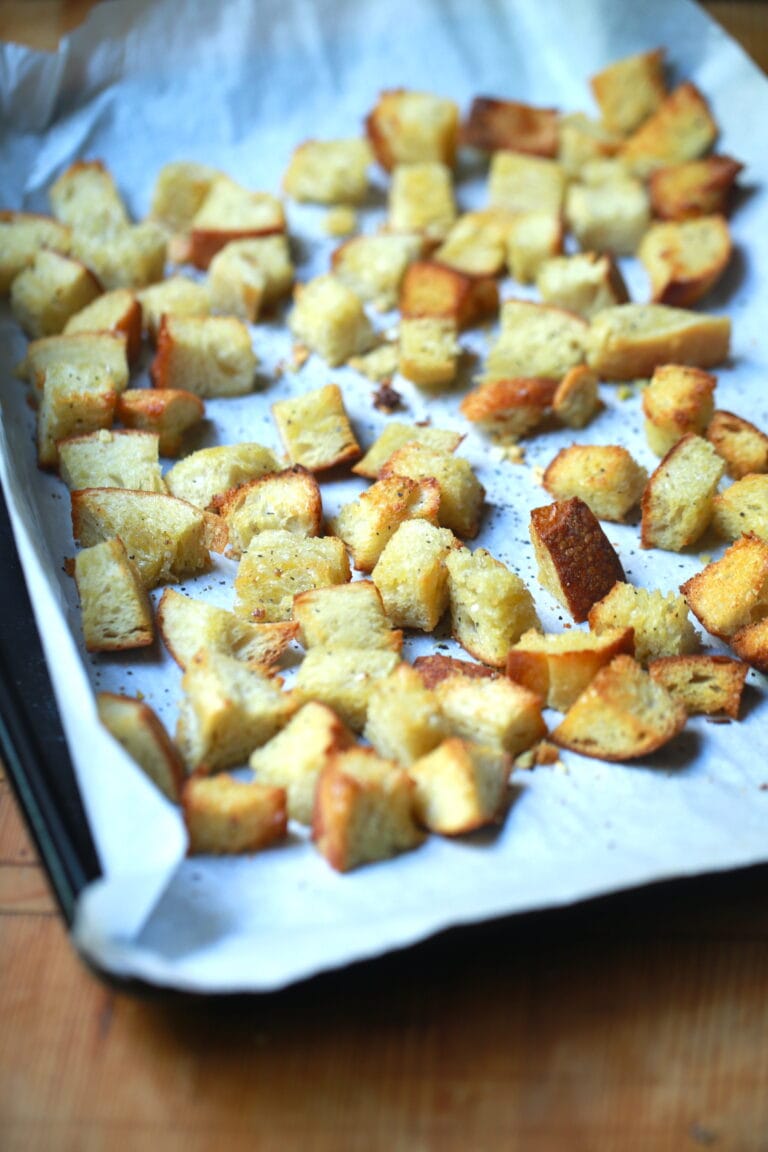 Crispy sourdough croutons baked on parchment lined baking pan