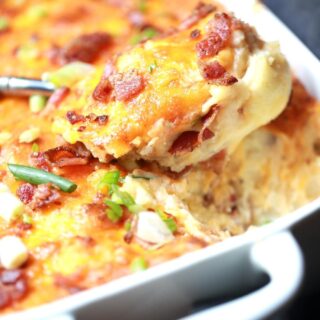 closeup spoonful of potato casserole from pan