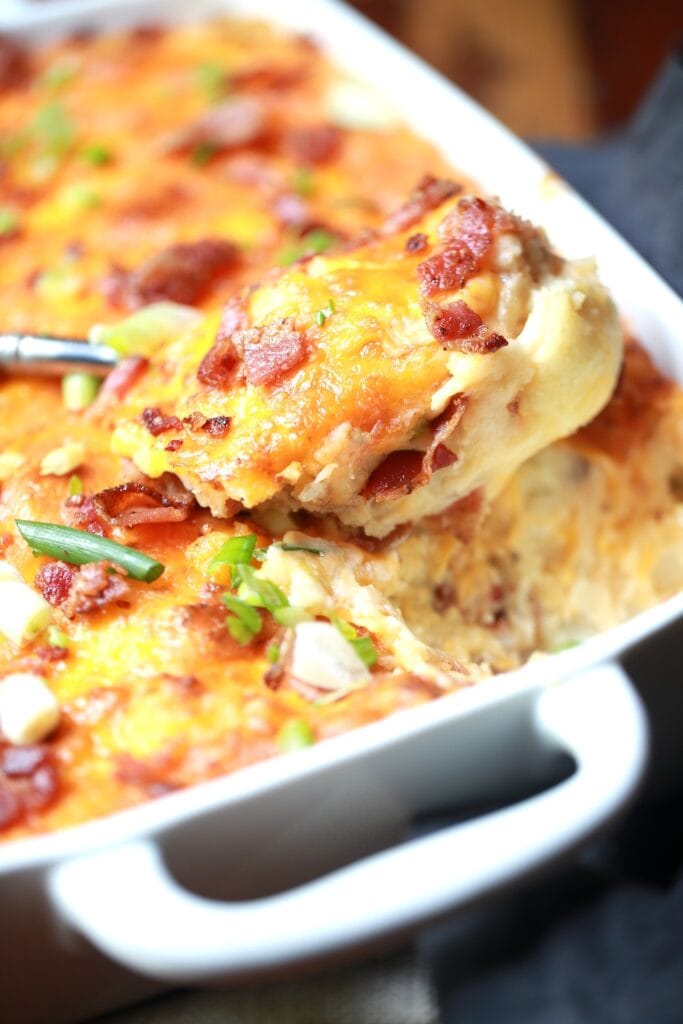 closeup spoonful of potato casserole from pan