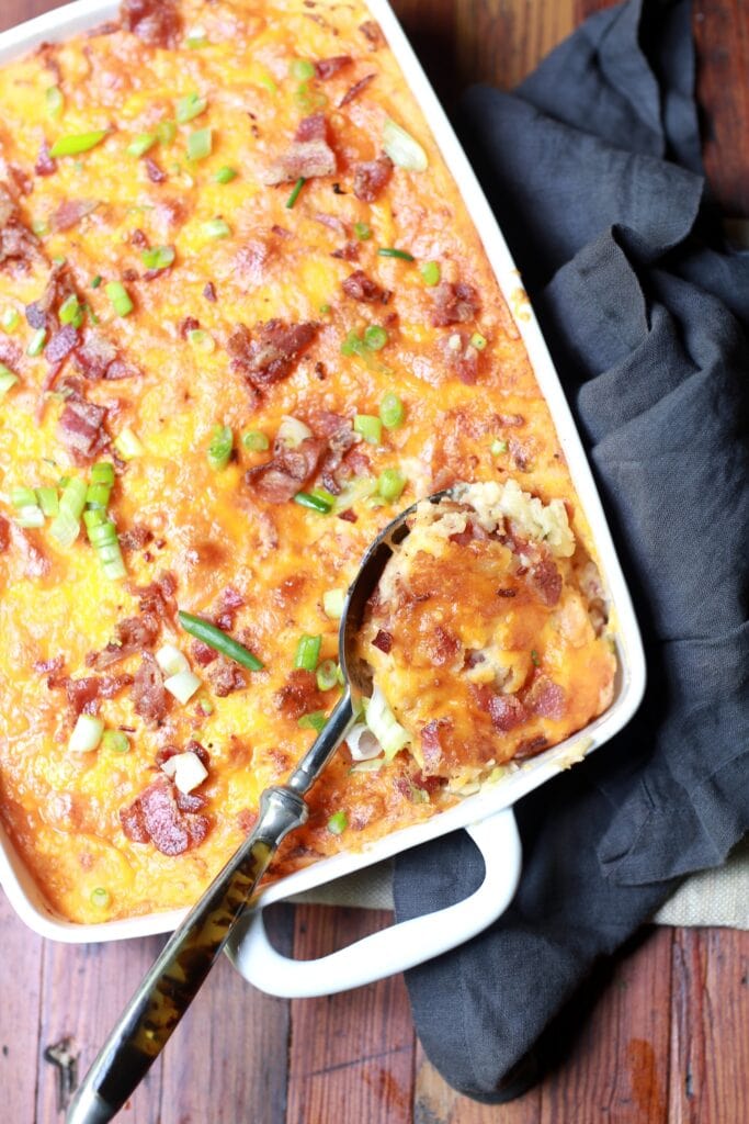 serving spoon digging into loaded twice baked potato casserole
