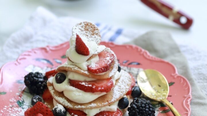 strawberry shortcake on pink plate with berries