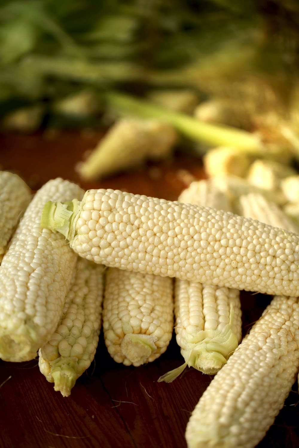 ears of corn on wooden surface