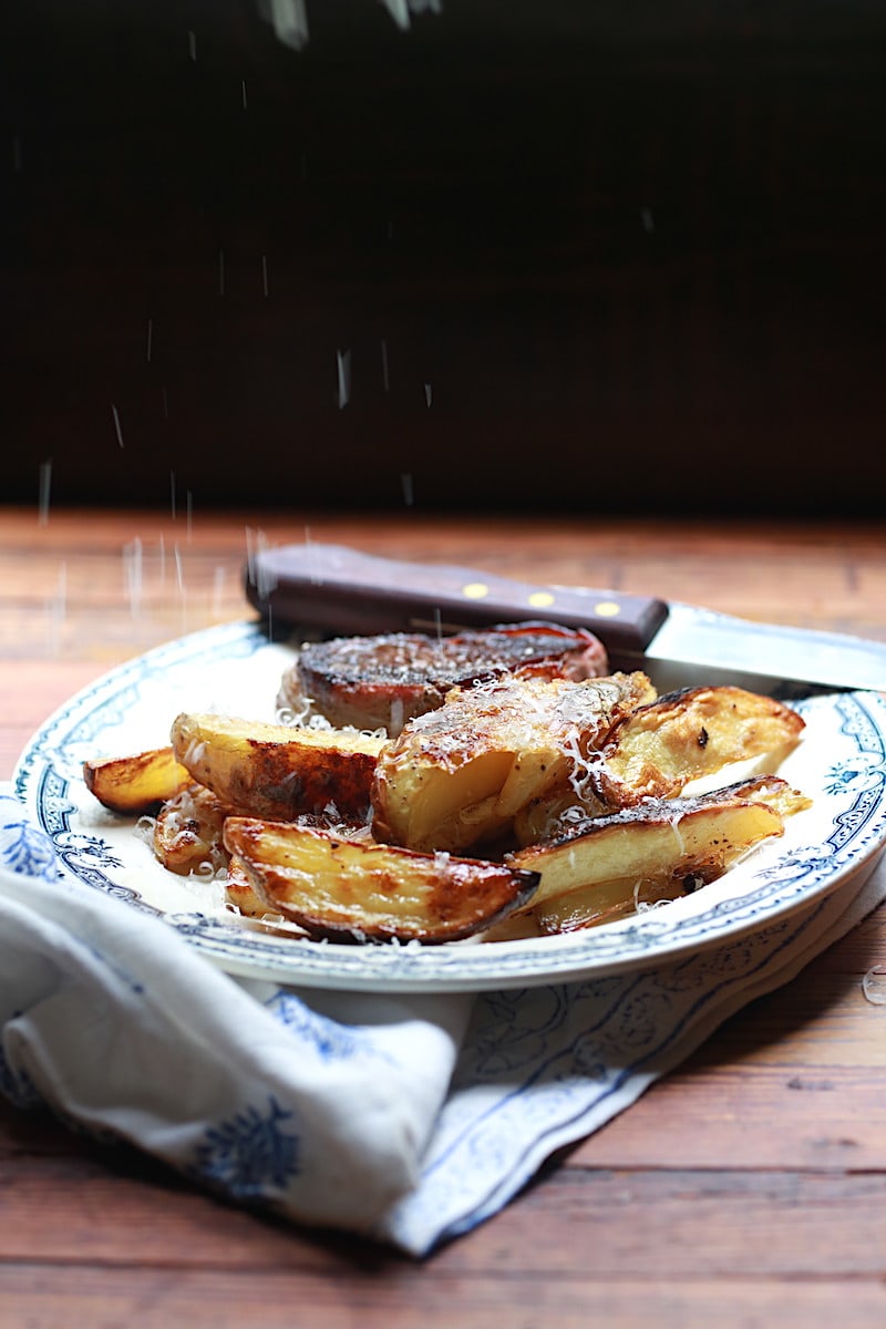 Plate with oven baked wedge fries alongside steak with parmesan