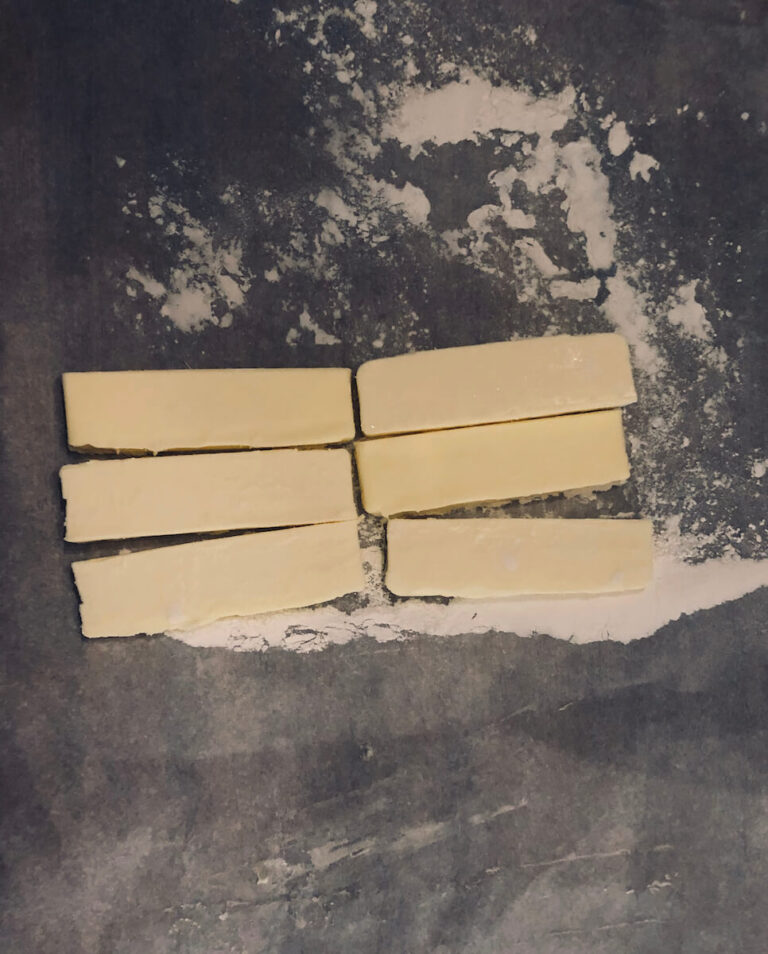 Slice each stick of butter lengthwise and place it on a floured piece of parchment paper.