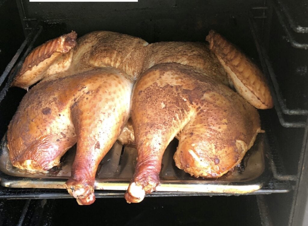 spatchcocked bird cooking in smoker 