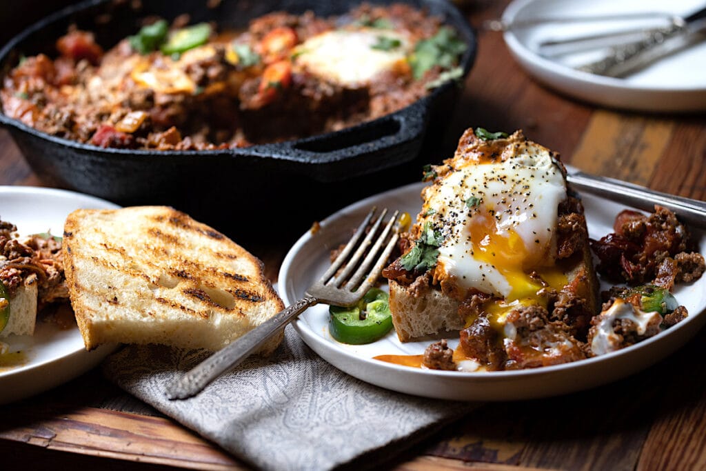 Plated Mexican breakfast skillet with ground deer meat, egg, and toast