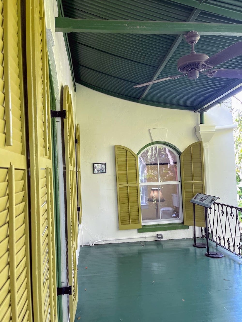 porch with yellow shutters at Hemingway house in Key West