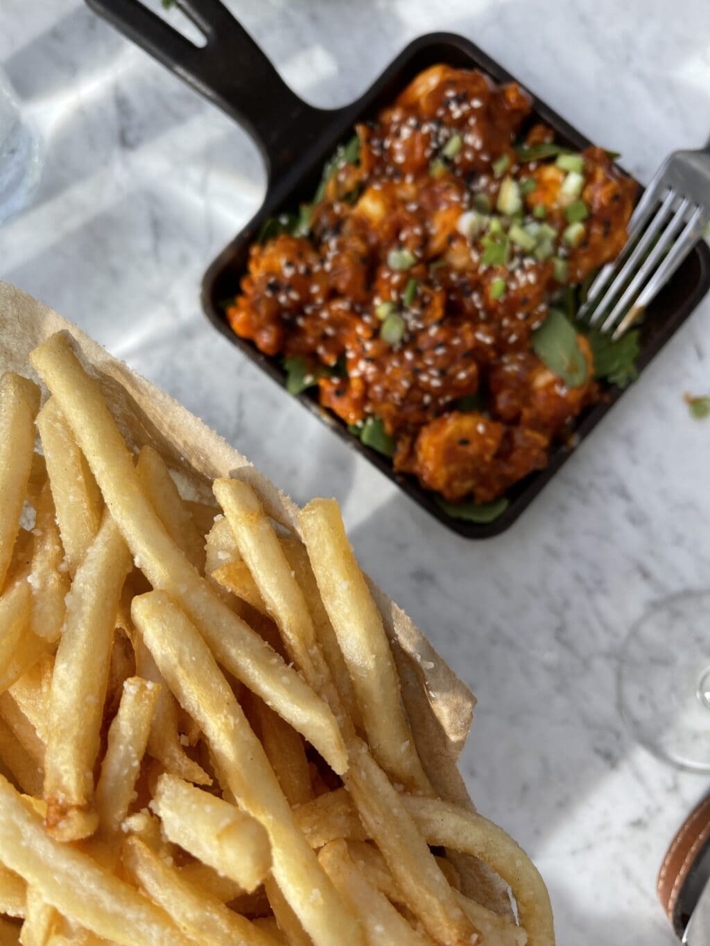 small pile of double fried French fries next to main dish