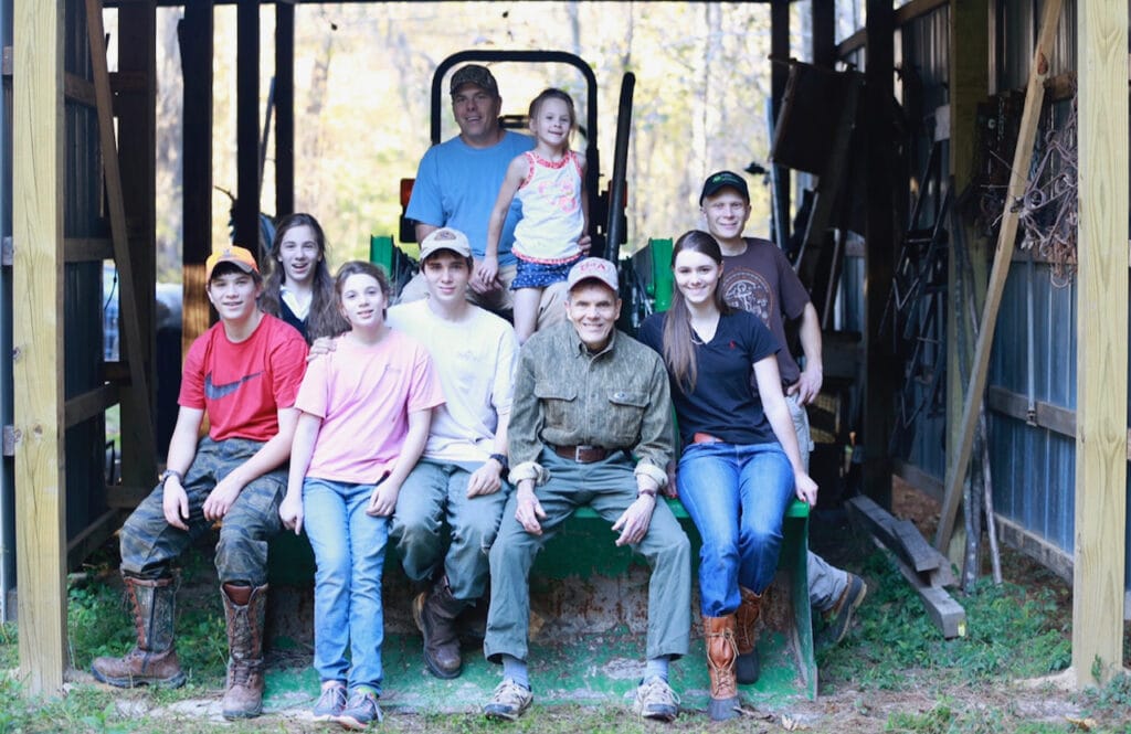 Stacy Lyn Harris's family gathered on back of tractor in barn