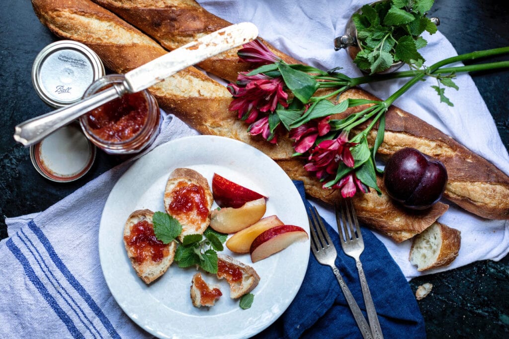 homemade strawberry jam on slices of French bread on white plate