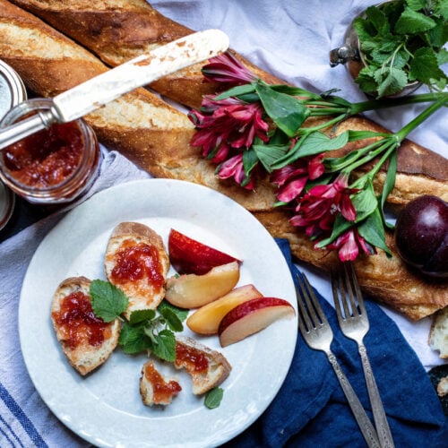 homemade strawberry jam on slices of French bread on white plate