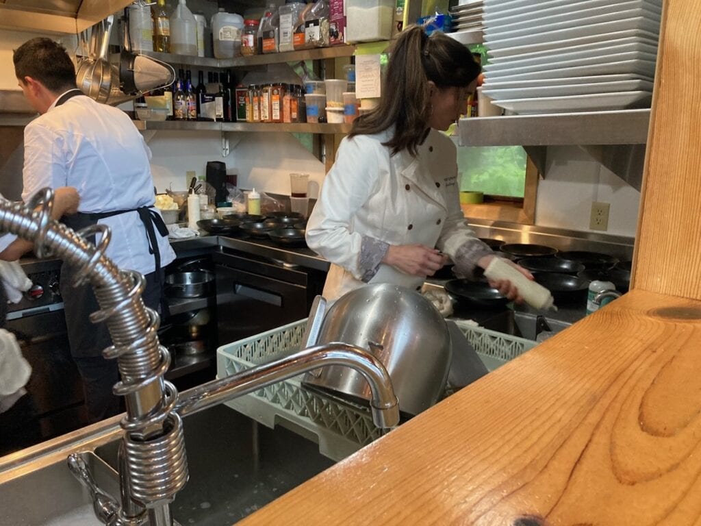 Stacy Lyn serving as guest chef, prepping food in kitchen at Talon Lodge in Alaska