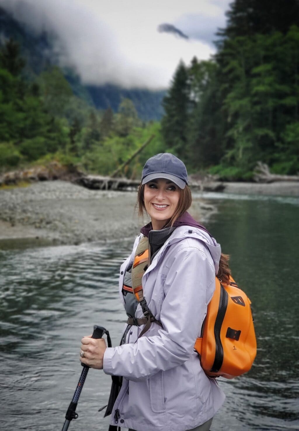 Stacy Lyn Harris standing in creek with gear for fly fishing in Sitka, Alaska