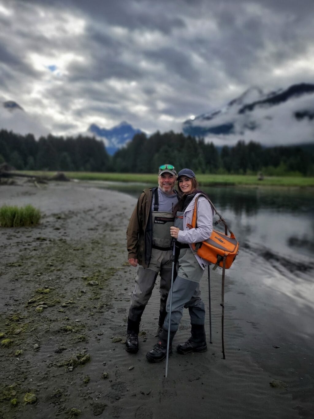 traveling to Alaska is worth it for the fly fishing - Stacy and Scott on beach with fishing gear