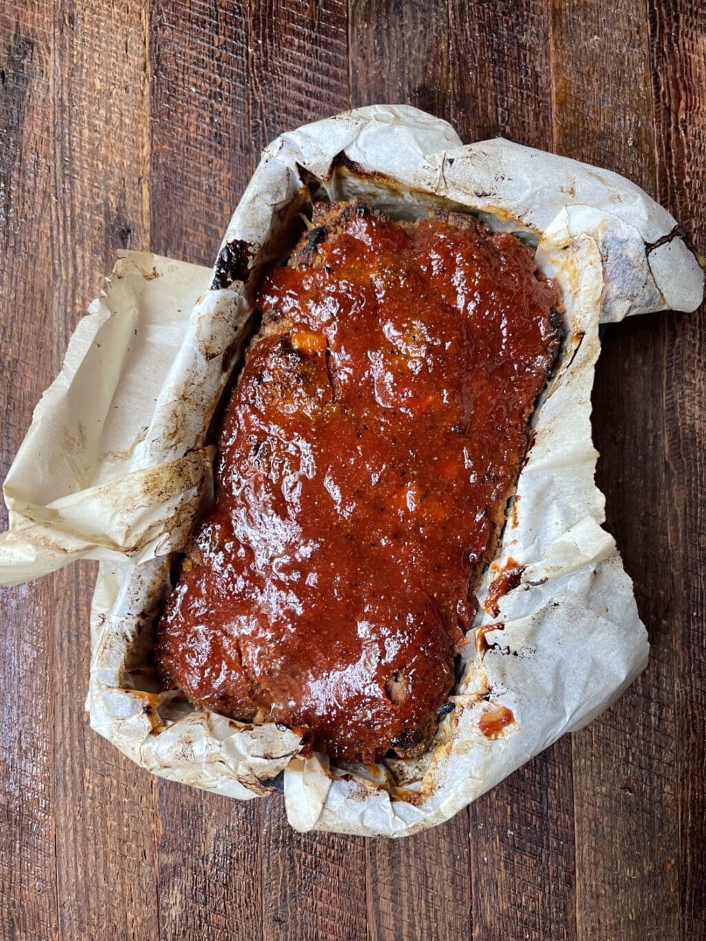 homemade meatloaf glazed, baked in loaf pan with parchment paper