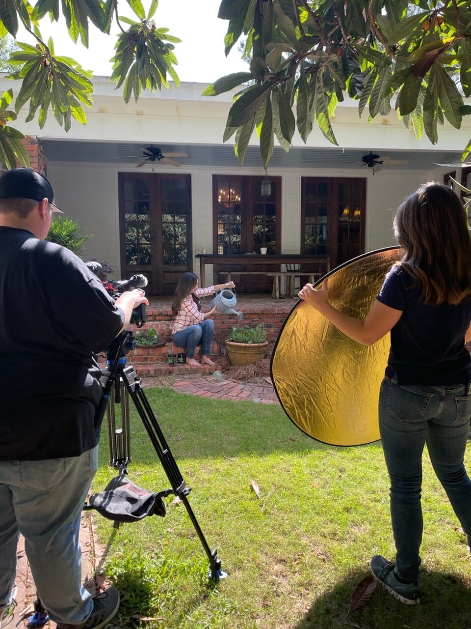 zoom out with Sporting Chef crew in foreground, filming Stacy Lyn on porch