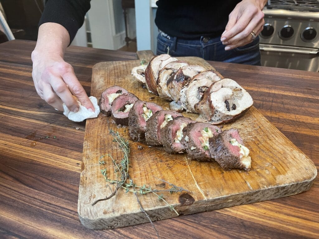 Stacy Lyn standing behind cutting board with sliced stuffed turkey