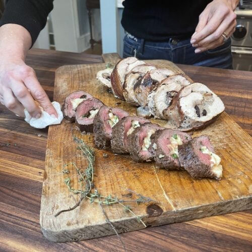 Stacy Lyn standing behind cutting board with sliced stuffed turkey