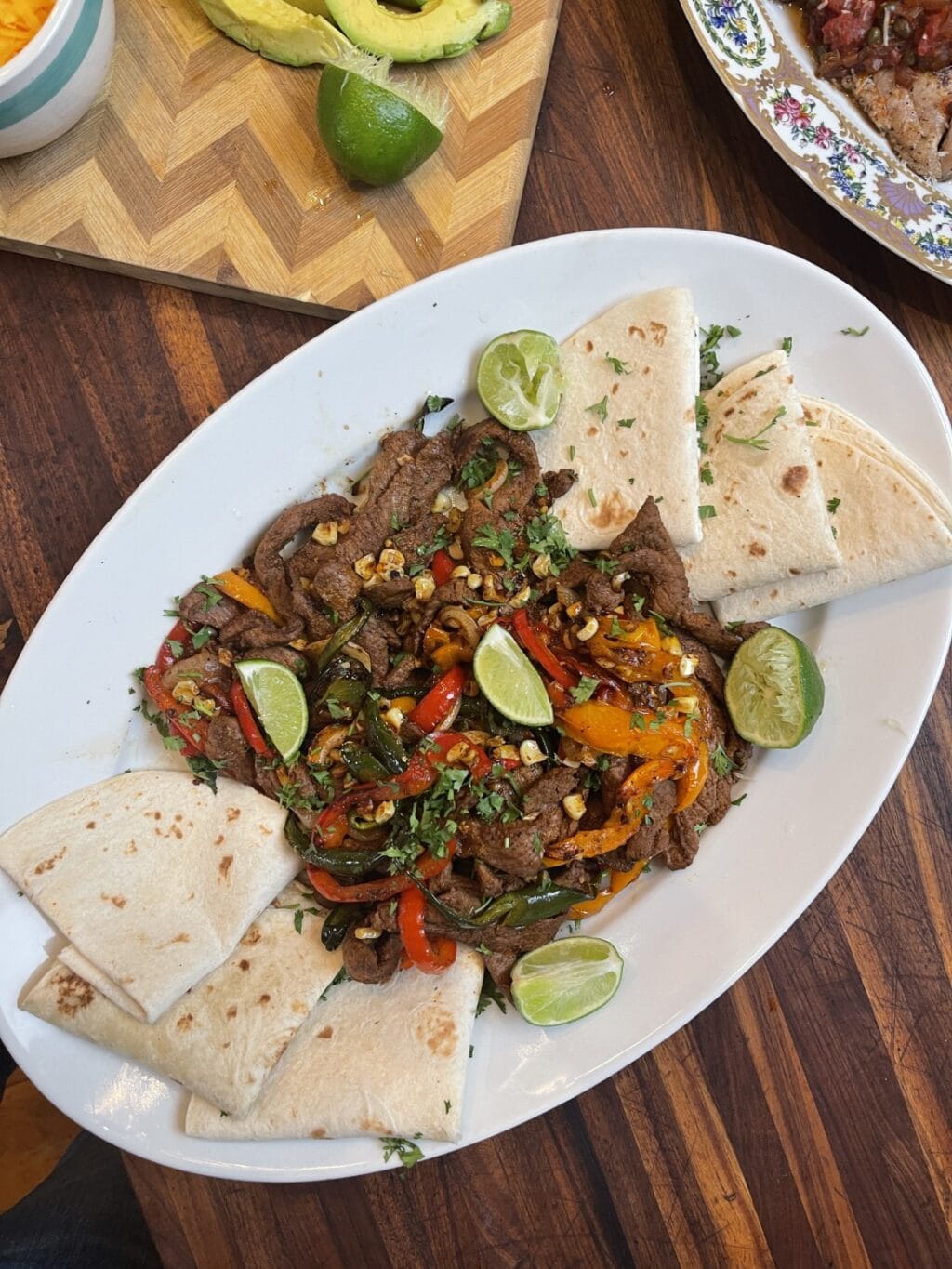 venison fajitas disassembled on white platter with folded tortillas