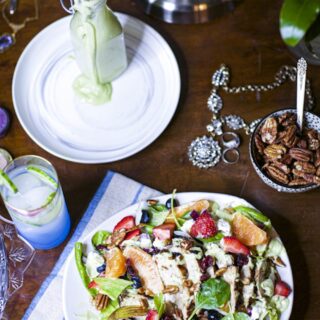 healthy salad with chicken in white bowl, drizzled with homemade avocado green goddess dressing