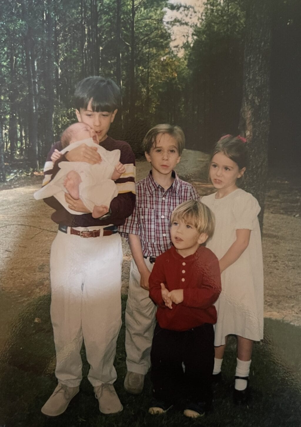 Forrest holding baby with other children when they were small