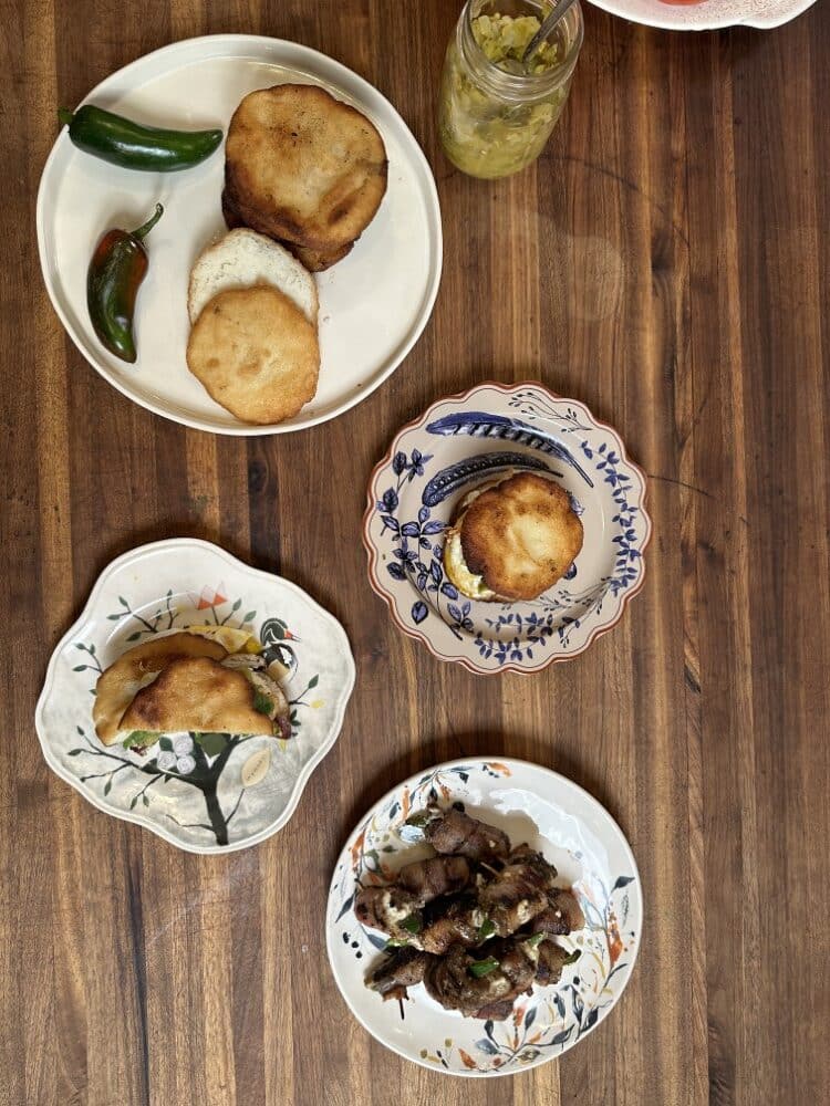 small, beautiful floral plates with arepas cakes, filling, and filled sandwiches