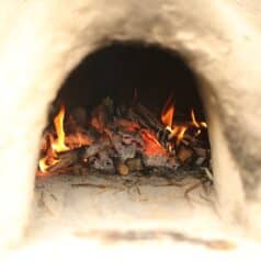 fire burning inside adobe mud oven