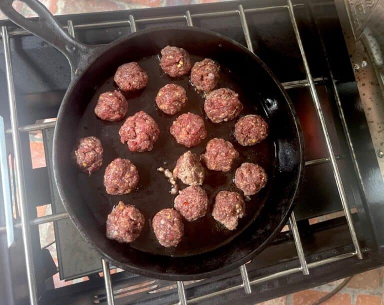 turkey sausage balls cooking in cast iron pan