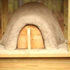 earthen oven with rounded wooden door in opening