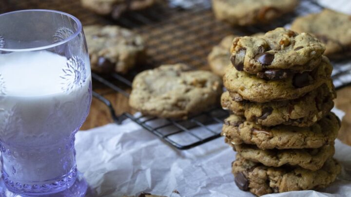 kitchen sink cookies in a stack next to a glass of milk