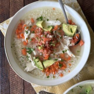 Bowl of Mexican chicken soup - callo de pollo - with chicken, rice, pico de gallo, and avocado